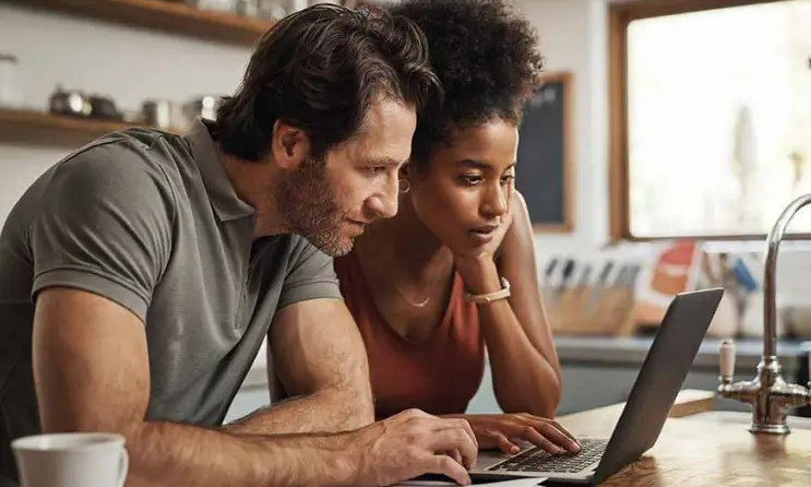 Couple reviewing paperwork together with concerned expressions