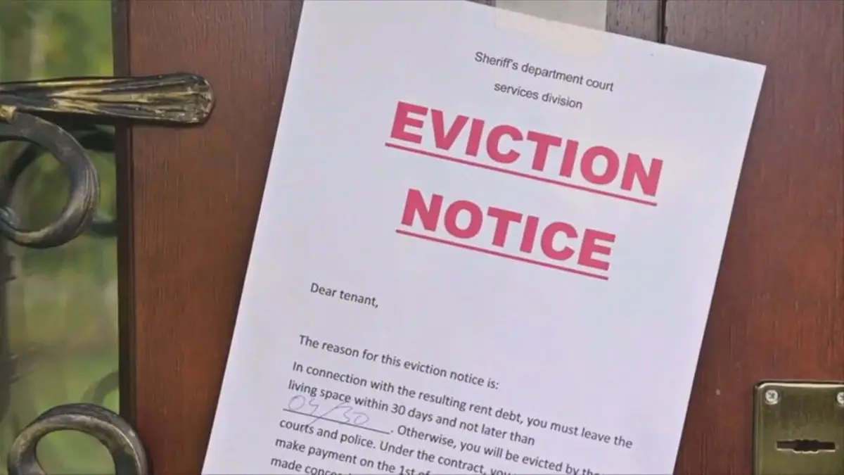 Red eviction notice hanging on a door