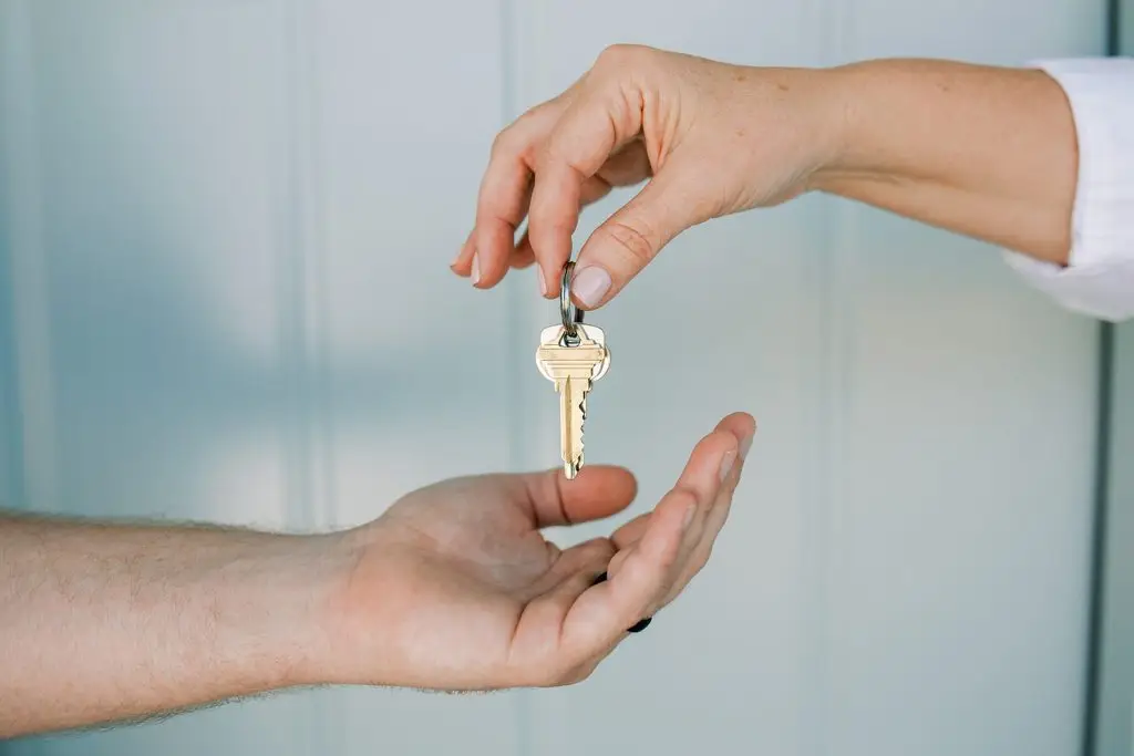 Hand handing over house keys to a new homeowner