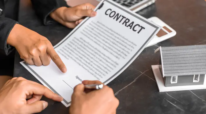 Person signing a real estate contract document