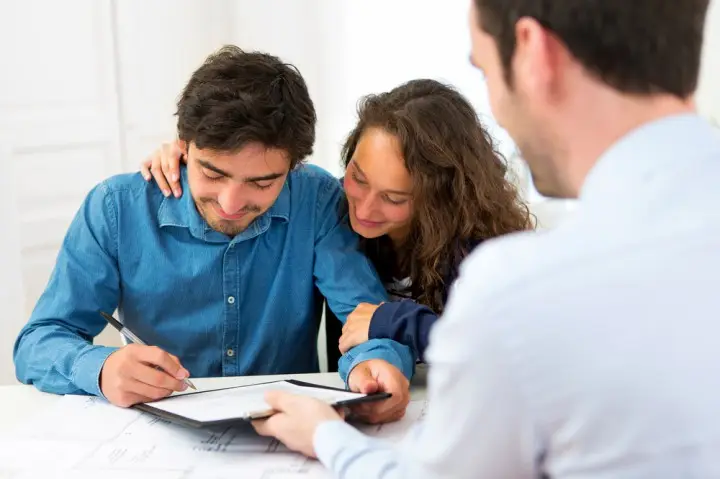 Couple reviewing finances with advisor while discussing home buying options