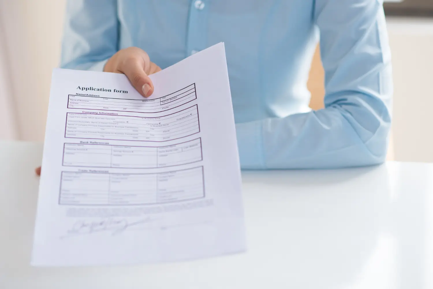 Closeup of a person giving a signed application form