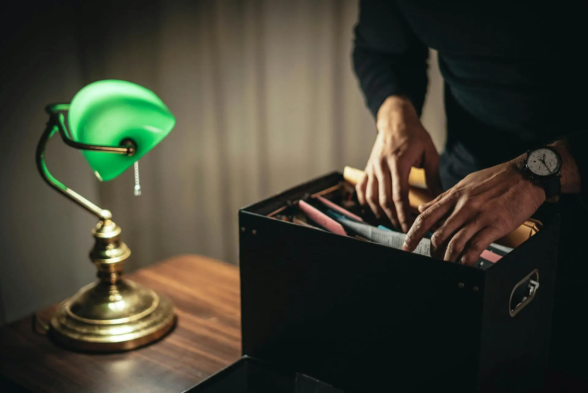 Sorting probate documents in file box on desk with lamp