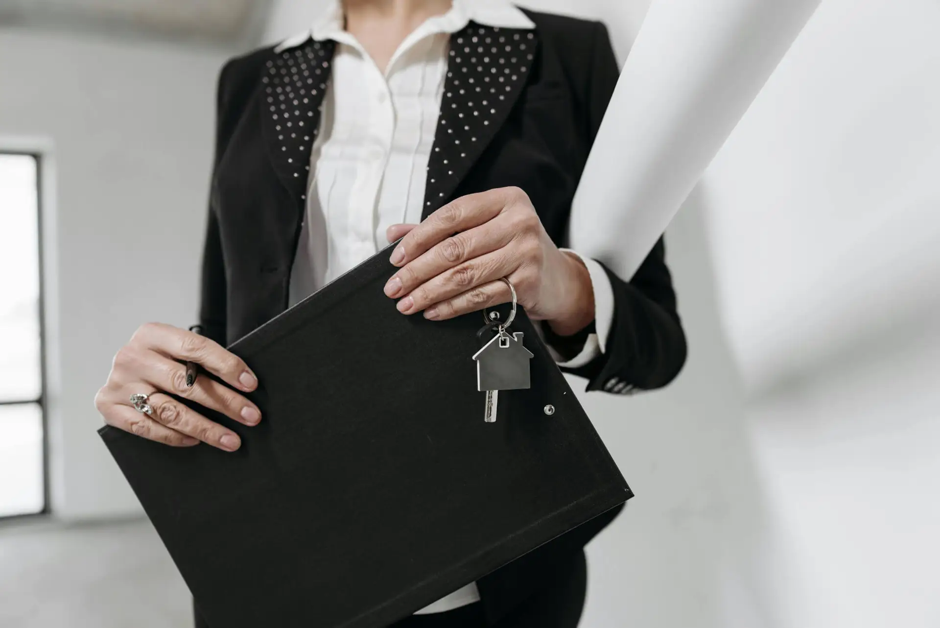 Professional holding real estate documents for property transaction or legal review